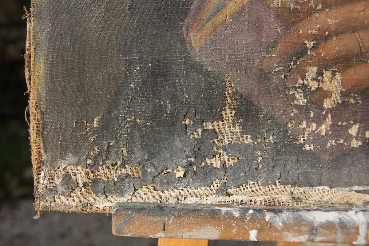 Bord de toile présentant des lacunes de couches picturales avant restauration de tableau ancien.