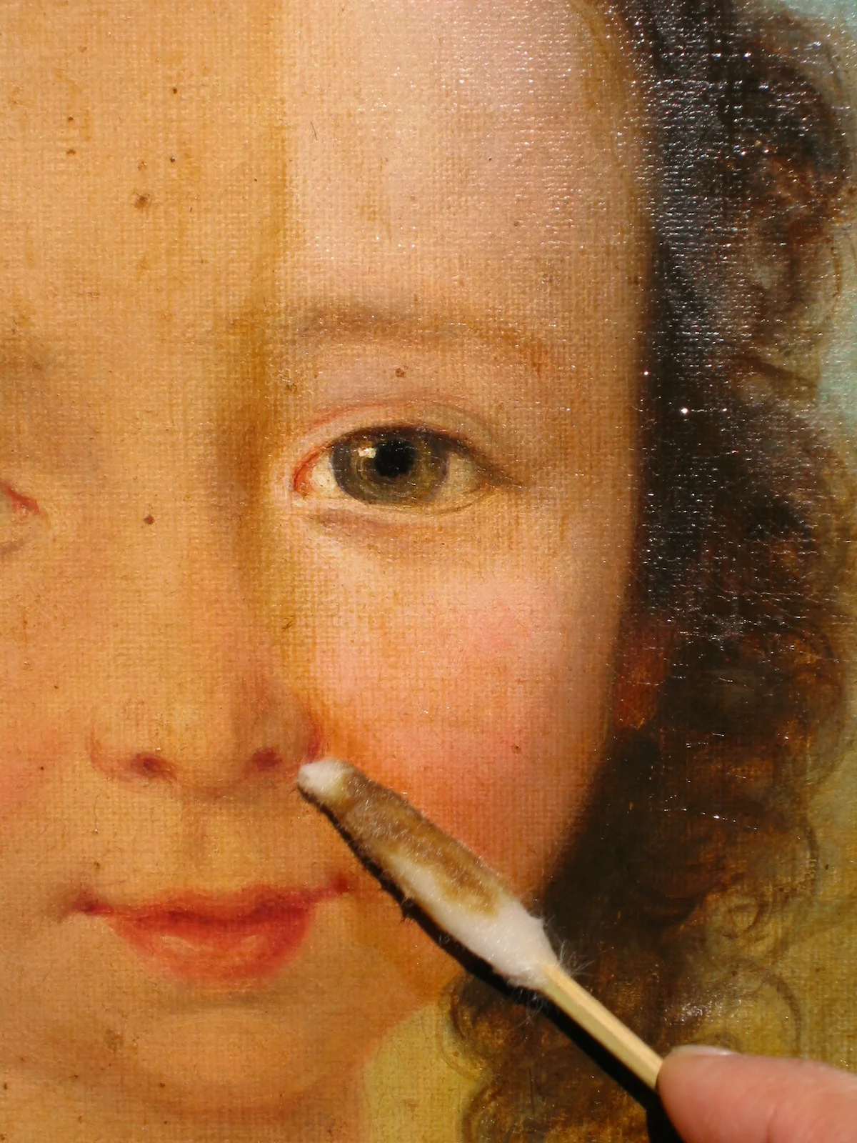 Nettoyage délicat du visage d’un enfant sur un tableau à Nice, attention portée aux chairs.