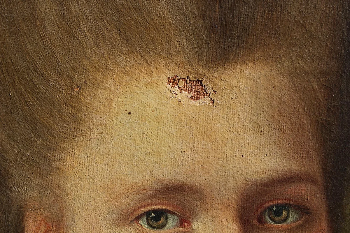 Détail de portrait présentant une lacune importante avant réintégration picturale, cas fréquent sur des tableaux anciens conservés sur la Côte d’Azur.
