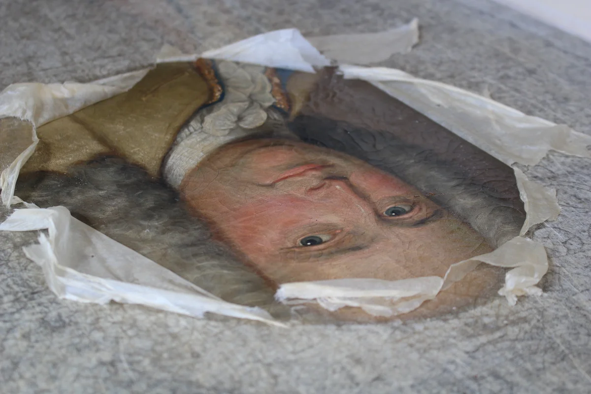 Facing de protection appliqué sur un portrait avant restauration.